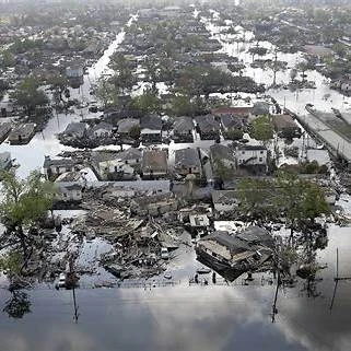 Flooded streets of New Orleans after Hurricane Katrina with damaged homes and rescue efforts.